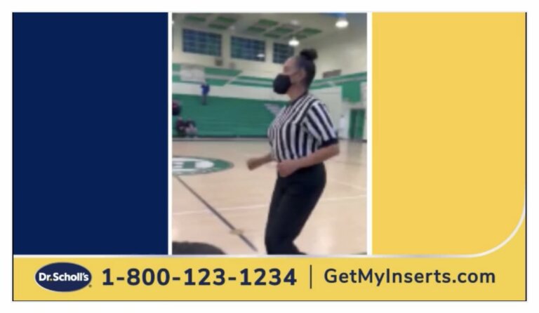 Crystal Nichols in a referee outfit on a basketball court with a mask on.